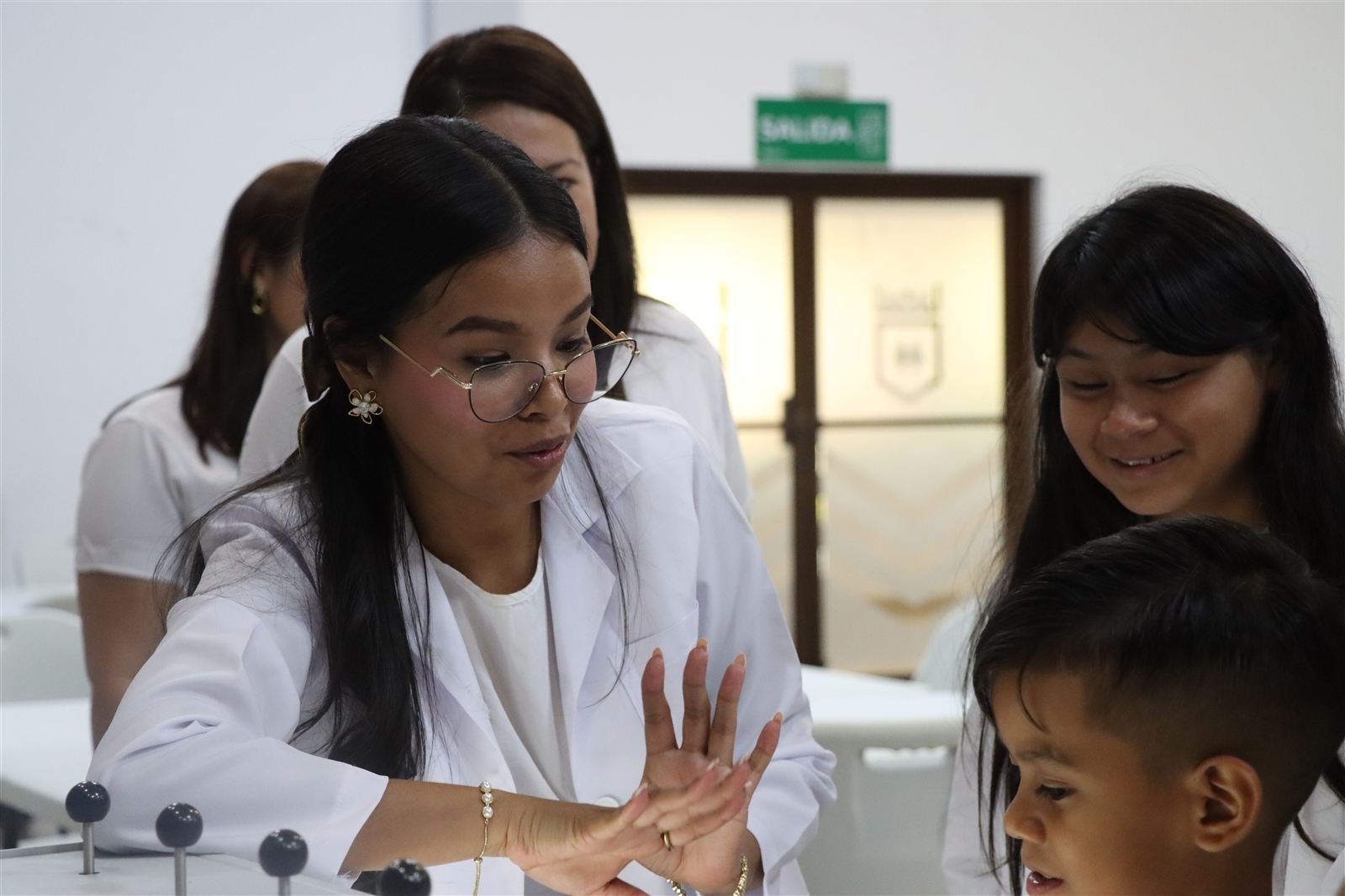 Una educadora acompaña a estudiantes en una experiencia práctica.